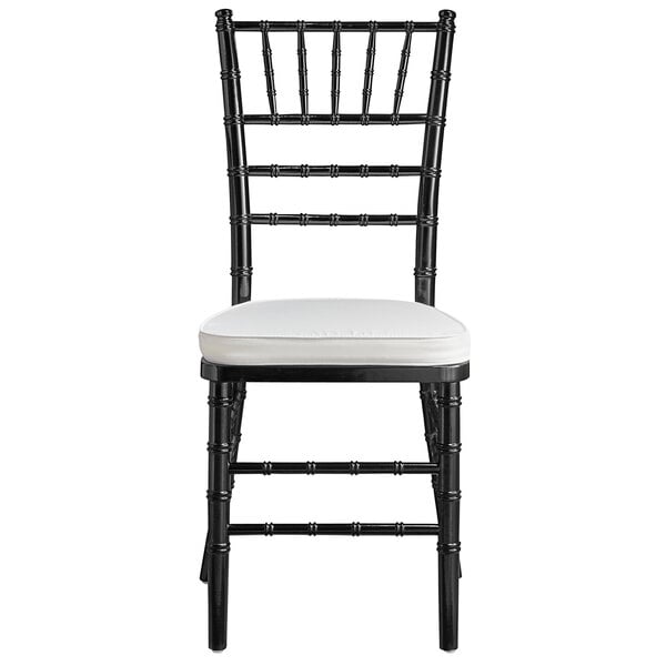 A Lancaster Table & Seating black Chiavari chair with ivory cushion.