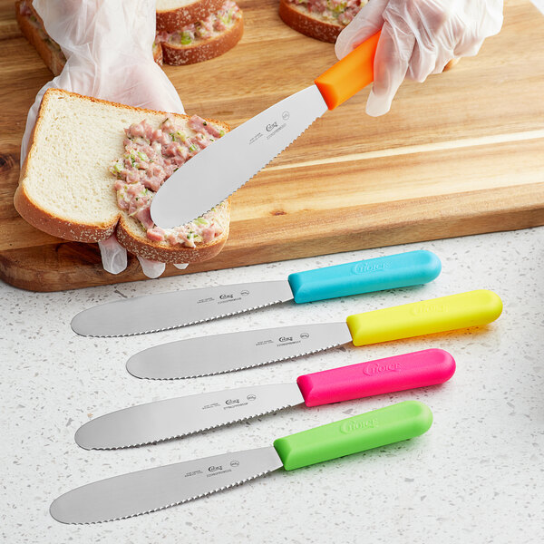 A Choice sandwich spreader with a blue handle spreading food on a piece of bread.