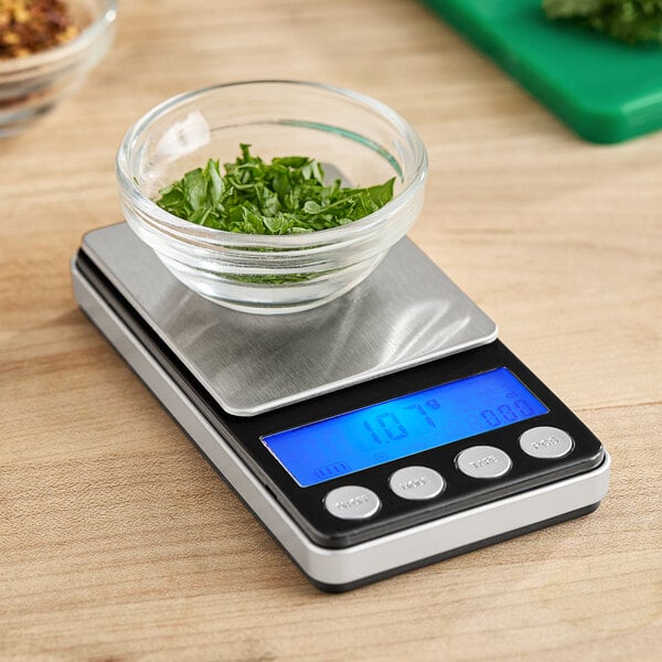 An AvaWeigh digital portion scale with a bowl of greens on top.