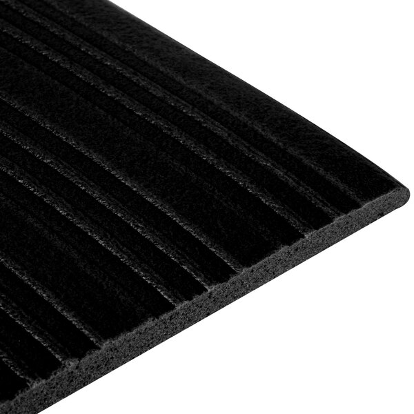 A close up of a black ribbed Tredlite anti-fatigue mat.