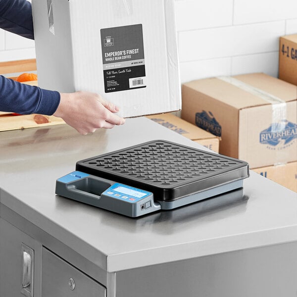 A digital receiving scale with a built-in handle and treaded platter on a countertop.