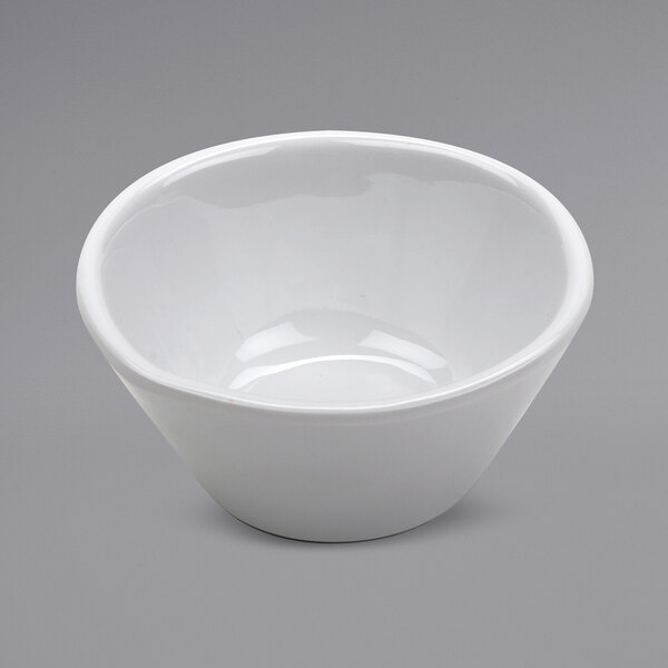 A white irregular ramekin with a shadow on a white background.