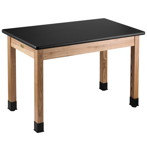 A black rectangular National Public Seating science lab table with wooden legs.