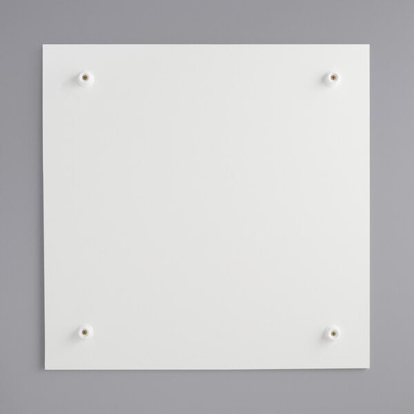 A white square melamine-coated wood cake board with feet.