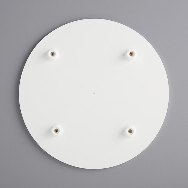 A white circular melamine-coated wood cake board with feet.