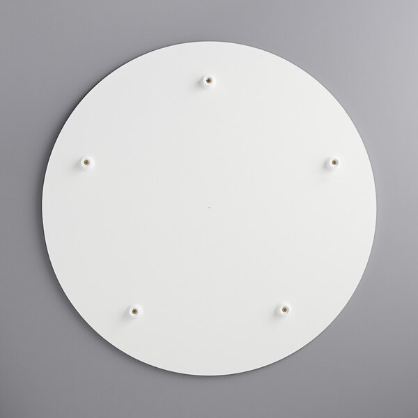 A white circular melamine-coated wood cake board with feet.