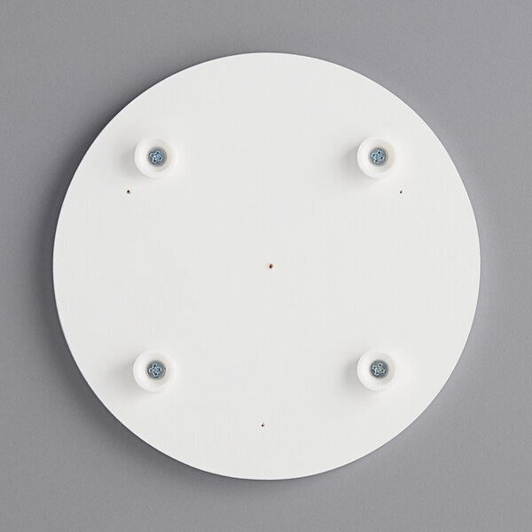 a white circular object with four screws