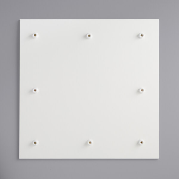 A white square melamine-coated wood cake board with feet and holes.