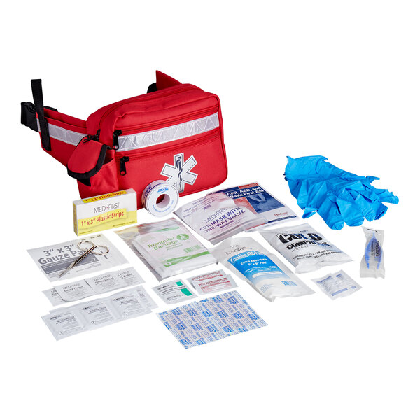 A basic first aid kit with various medical supplies and a red fanny pack.