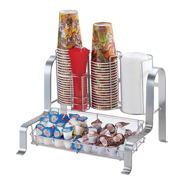 A silver condiment organizer holding cups, lids, stirrers, and creamers.