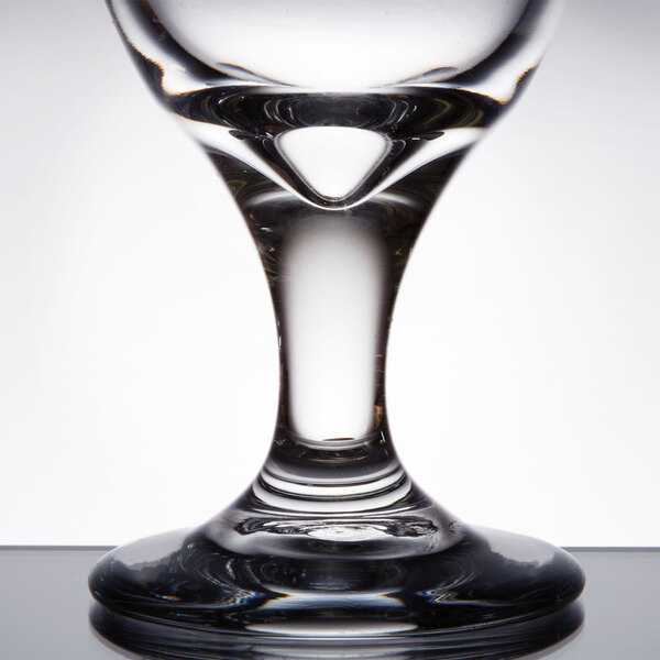 A close up of a clear Libbey tall iced tea glass with a small hole in it.