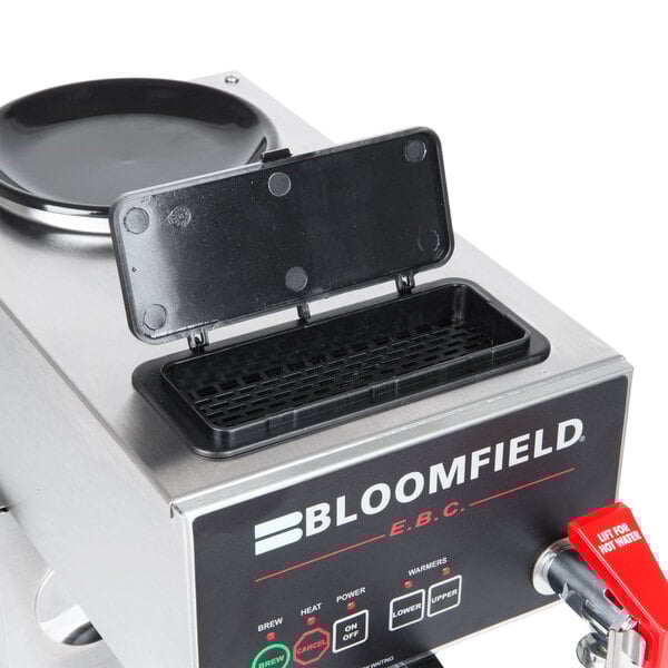 A black and silver Bloomfield automatic coffee brewer with a black plastic touchpad lid.
