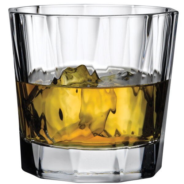 A Nude Hemingway rocks glass with yellow liquid and ice.