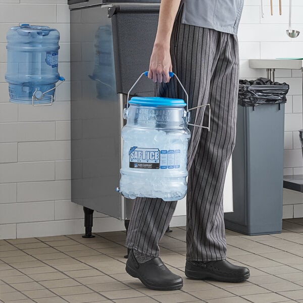 A man in a chef's uniform using a San Jamar Shorty Saf-T-Ice polycarbonate container to carry ice.