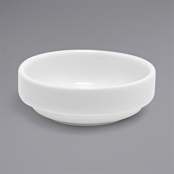 A Front of the House Monaco bright white porcelain ramekin on a gray surface.