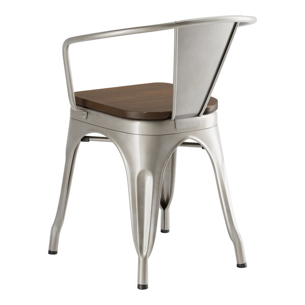 A Lancaster Table & Seating metal arm chair with a walnut wood seat.