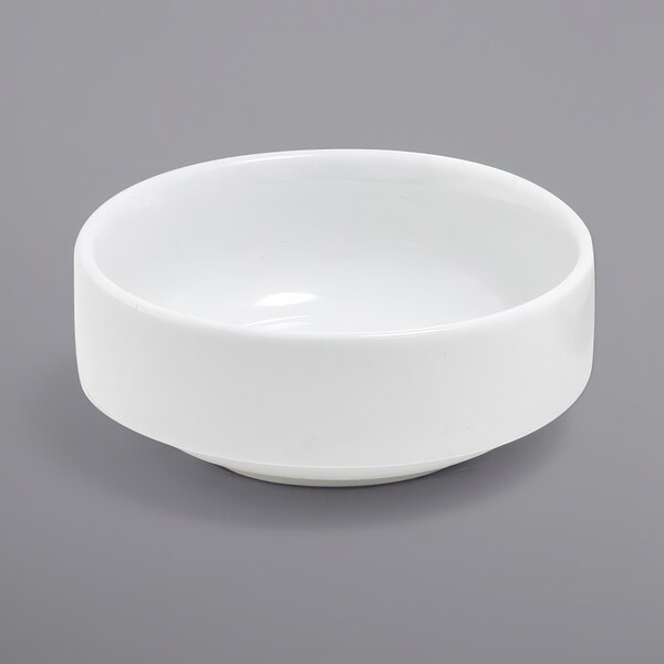 A Front of the House Monaco bright white porcelain ramekin on a gray surface.