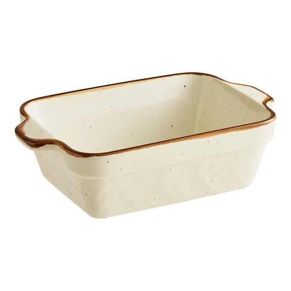 A rectangular vanilla bean porcelain baker or casserole dish with a brown rim and handles.