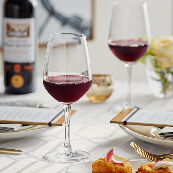 A table with Acopa Radiance wine glasses and food on it.