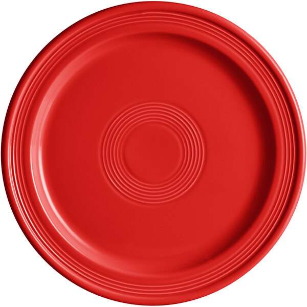 A close-up of an Acopa Capri Passion Fruit Red stoneware plate with a circular pattern.