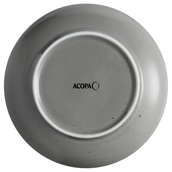 A white stoneware coupe plate with black text that reads "Acopa Keystone"