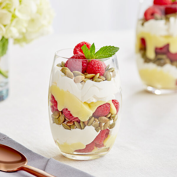 A close-up of an Acopa Covella Highball Glass filled with a raspberry and white chocolate dessert with fruit and cream.
