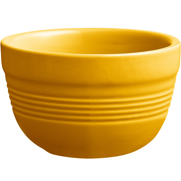 An Acopa Capri mango orange stoneware bouillon bowl with a handle on a white background.