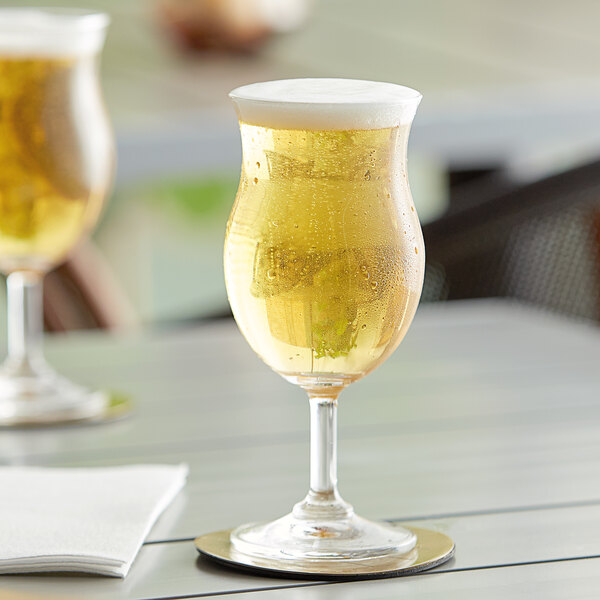 Two Acopa Select Belgian beer glasses on a table.