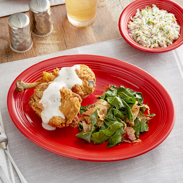 An Acopa Capri Passion Fruit Red stoneware platter with food on a table.