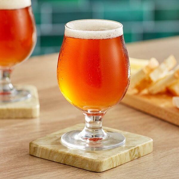 Two Acopa Select Belgian beer glasses on a table