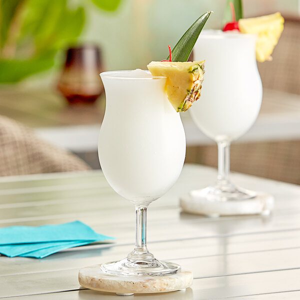 An Acopa Poco glass filled with a white cocktail with a pineapple slice on the rim.