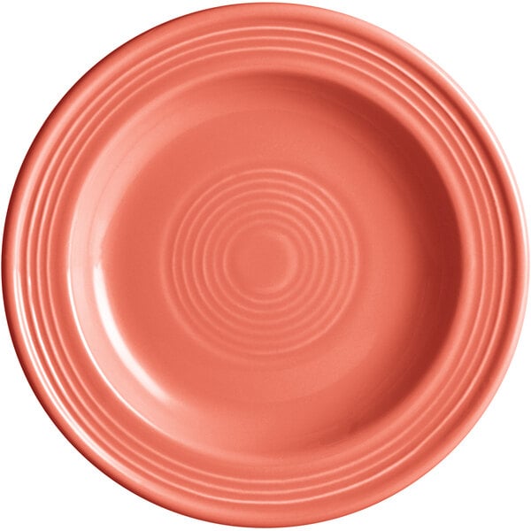 An Acopa Capri stoneware plate in coral with a spiral pattern.