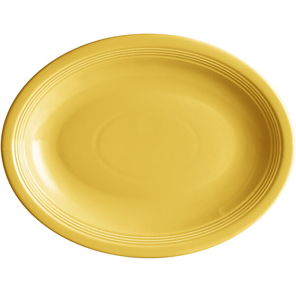 An Acopa Capri citrus yellow oval stoneware coupe platter with a white background and a ring on it.