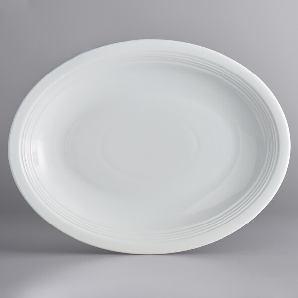 An Acopa Capri coconut white stoneware coupe platter with a curved edge on a white background.