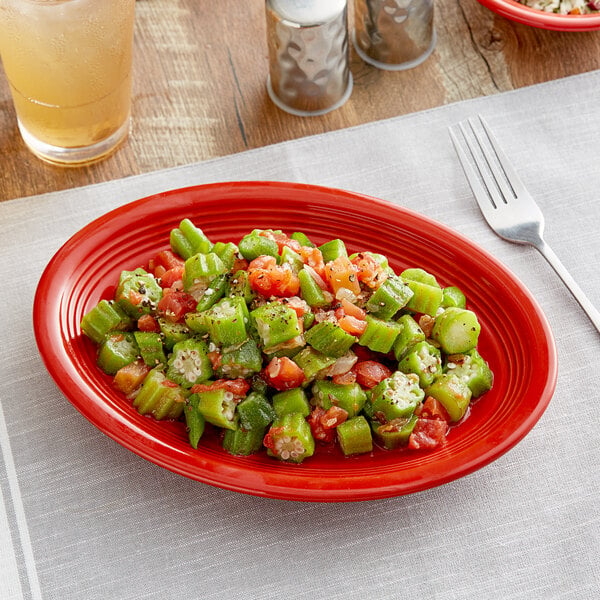 An Acopa Capri passion fruit red oval stoneware coupe platter with food on it.