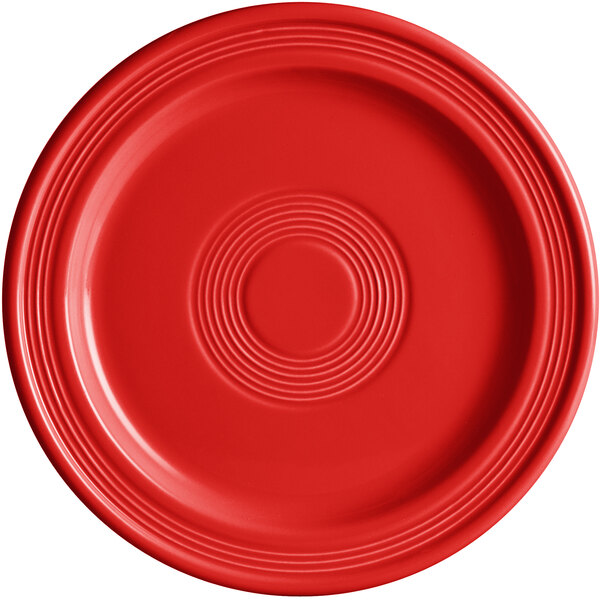 A close-up of a red Acopa Capri stoneware plate with a circular pattern.