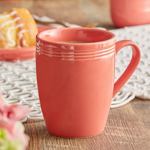 An Acopa Capri coral reef mug filled with coffee on a table with pastries.