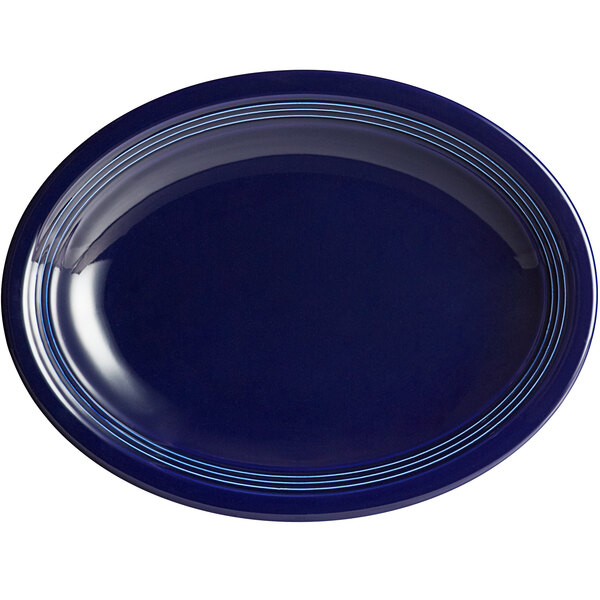 An Acopa Capri deep sea cobalt oval stoneware coupe platter with blue lines on a white background.