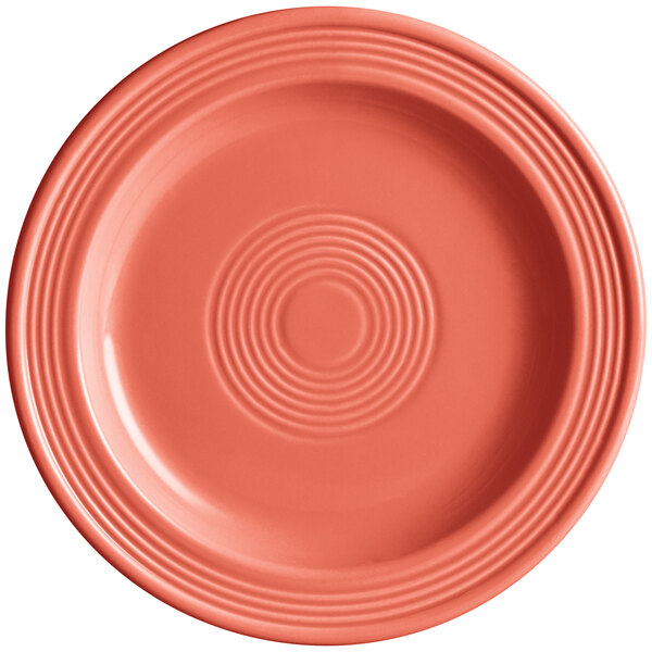 An Acopa Capri stoneware plate in coral with a spiral pattern on the rim.