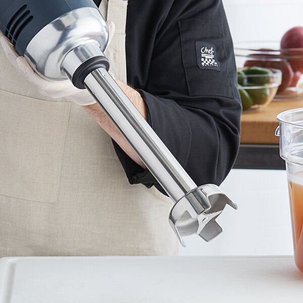 A person using an AvaMix blending shaft to blend a green smoothie.