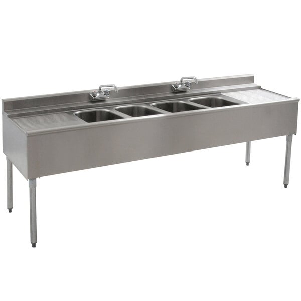 An Eagle Group stainless steel underbar sink with four compartments and two drainboards.
