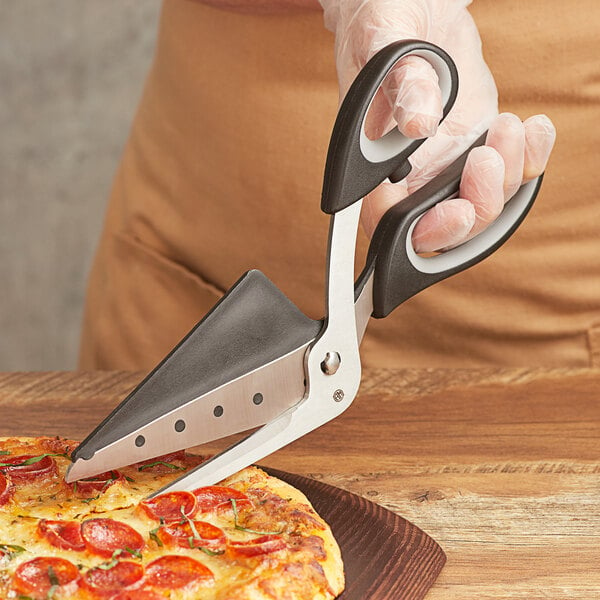 A person cutting a pizza with American Metalcraft pizza scissors.