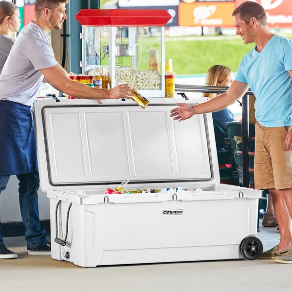 Two men pouring beer into a white CaterGator outdoor cooler.