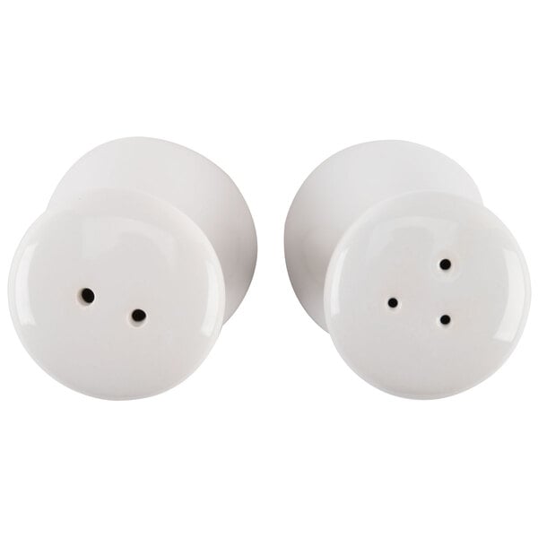 A close-up of two white American Metalcraft ceramic tower salt and pepper shakers.