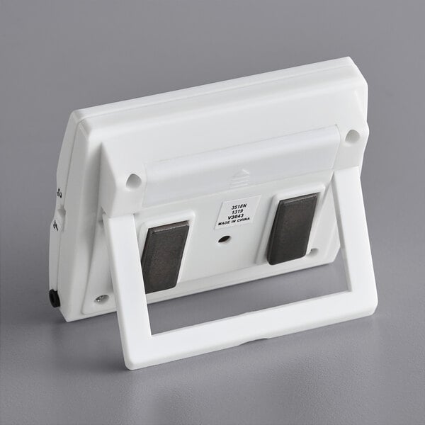 A white rectangular wall mount with black handles.