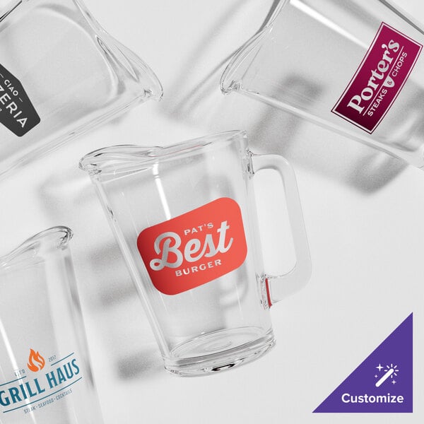 An Acopa glass beer pitcher with a red label.