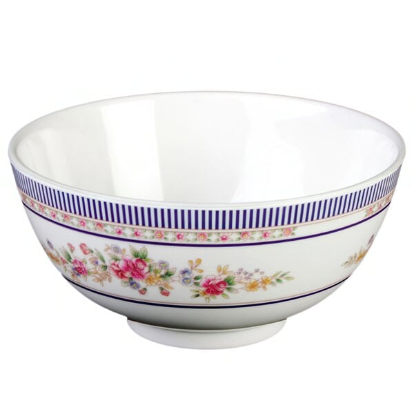 A white bowl with blue roses and flowers on it.