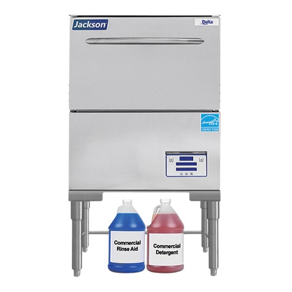 A Jackson DishStar high temperature glasswasher on a counter with two containers of liquid.