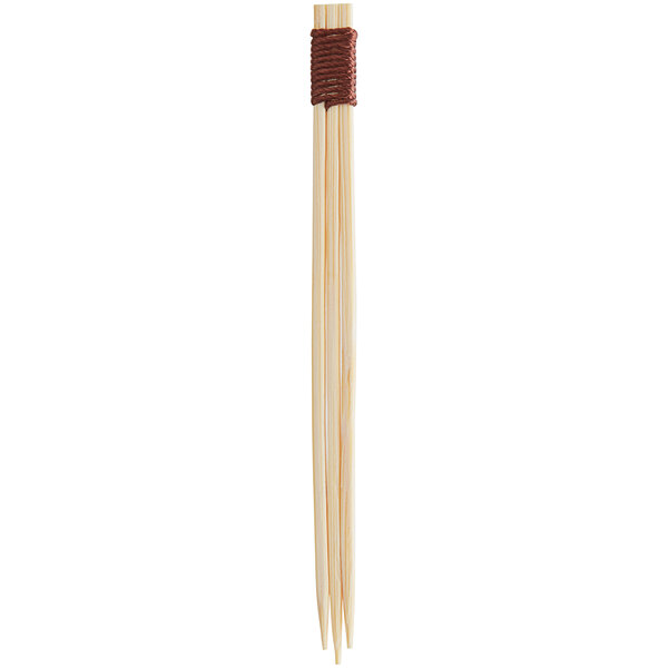 A close up of a pair of Bamboo Triple / Trident Skewers with brown handles.