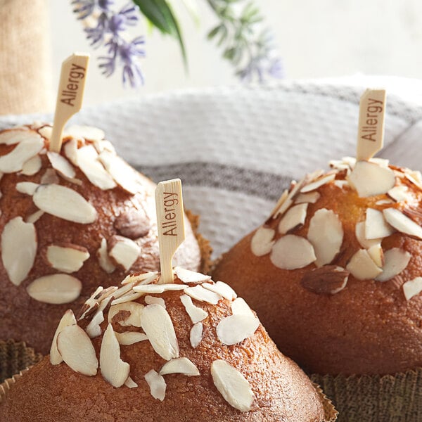 Three muffins with almonds on top and Bamboo by EcoChoice Compostable bamboo picks on a table.